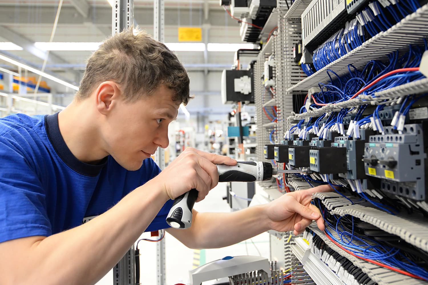 Techniker bei der Verdrahtung eines industriellen Schaltschrankes mit strukturierter Kabelverlegung und moderner Automatisierungstechnik - Schaltschrankbau bei WTA Wachsmuth in Hanau